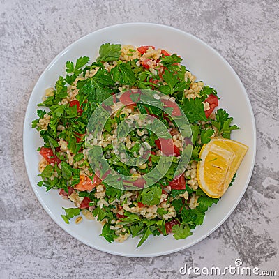 Middle Eastern cuisine. Vegetarian salad with bulgur, vegetables. Fresh bright arabic salad. Tabbouleh salad Stock Photo