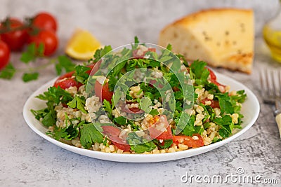 Middle Eastern cuisine. Vegetarian salad with bulgur, vegetables. Fresh bright arabic salad. Tabbouleh salad Stock Photo