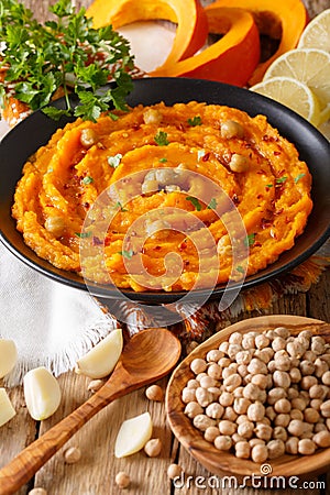 Middle Eastern food: pumpkin hummus with garlic, lemon and pepper closeup. vertical Stock Photo