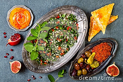 Middle Eastern traditional dinner. Authentic arab cuisine. Tabbouleh, sambusek, muhammara, pumpkin hummus. Stock Photo