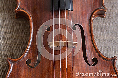 The middle part of a violin body with the f holes, the bridge and a part of the strings. Stock Photo
