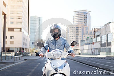 Middle shot of a young motorcyclist stopped at a traffic light in Barcelona. The man rides through the city on Stock Photo