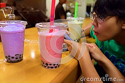 Phone Surfing and Boba Tea Editorial Stock Photo