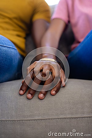 Midsection of african american couple hands holding hands at home Stock Photo