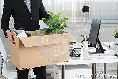 Midsection Of Businessman Carrying Cardboard Box Stock Photo