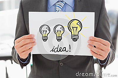 Midsection of businessman holding bill board with bulb sign and idea text Stock Photo