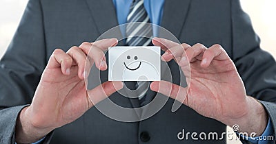 Midsection of businessman holding smiley face on card Stock Photo