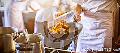 Midsection of chef cooking in kitchen stove Stock Photo