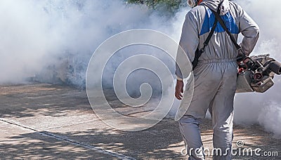 Midsection of outdoor healthcare worker using fogging machine spraying chemical to eliminate mosquitoes in public area Stock Photo