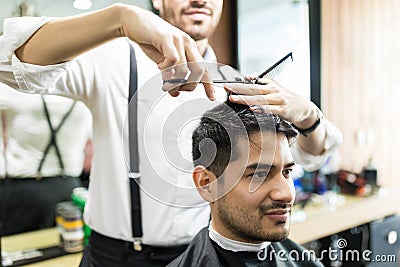 Professional Barber Giving Haircut To Male In Shop Stock Photo