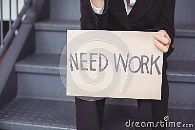 Midsection of unemployed businesswoman with need work placard Stock Photo