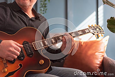 Midsection view of a man playing a vintage jazz guitar Stock Photo