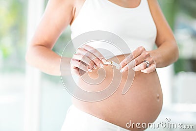 Midsection of woman breaking cigarette Stock Photo