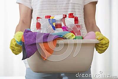 Midsection of woman carrying basket of cleaning supplies Stock Photo