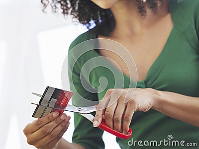 Midsection Of Woman Cutting Credit Card Stock Photo