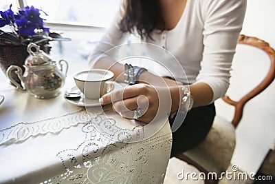 Midsection of woman having coffee at cafe Stock Photo