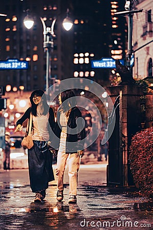 Midtown Manhattan street scene viewed at night with people, cars and building Editorial Stock Photo