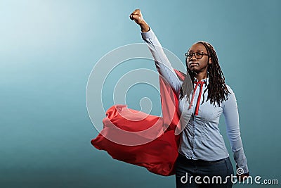 Mighty and brave african american superhero woman posing as justice defender while acting like flying on blue background Stock Photo