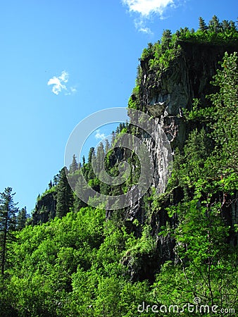 Mighty rocks surrounded by green foliage Stock Photo