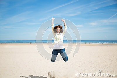 Miidle aged woman jumping on the beach Stock Photo