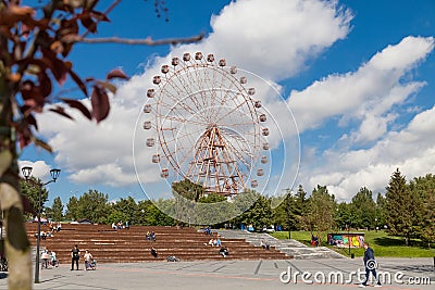 Mikhailovskaya embankment in the city of Novosibirsk on a summer day with wooden steps - benches on which people sit and rest Editorial Stock Photo
