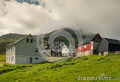Mikladalur, Faroe Islands - 07/07/2019Village Mikladalur on a sunny summer day, mountain in the background covered in clouds, Editorial Stock Photo