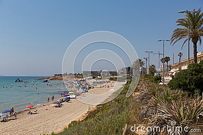 Mil Palmeras beach Costa Blanca Spain with palm trees and holidaymakers with parasols in beautiful summer weather Stock Photo