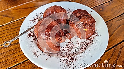 Milan - Chocolate Profiterole. Sweet dessert on white plate. Homemade profiteroles with cream Stock Photo