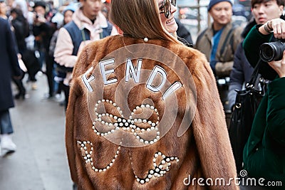 MILAN - FEBRUARY 22: Woman with brown fur jacket with pearls decoration smiles to photographers before Fendi fashion show, Milan Editorial Stock Photo