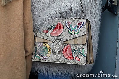 Woman with Gucci bag with butterfly and flowers decorations and gray, fur coat before fashion Albino Teodoro Editorial Stock Photo