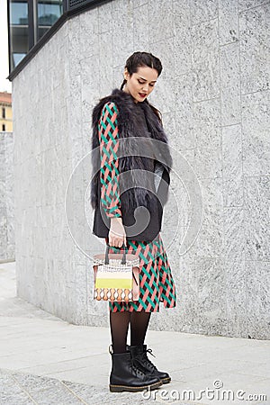 Woman poses for photographers with black fur and intricate design dress before Costume National fashion show Editorial Stock Photo