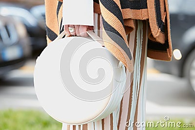 Woman poses for photographers with white round bag before Fendi fashion show, Milan Fashion Week Day 2 street Editorial Stock Photo