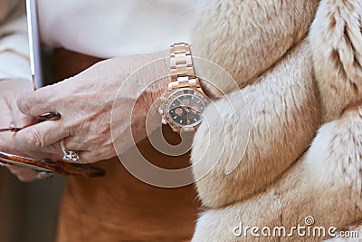 Woman with Rolex Daytona cronograph in yellow gold before Blumarine fashion show, Milan Fashion Week street Editorial Stock Photo