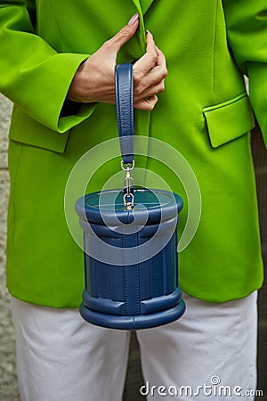 Woman with blue leather bag and green jacket before Genny fashion show, Milan Fashion Week Editorial Stock Photo