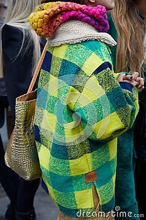 MILAN, ITALY - FEBRUARY 22, 2023: Woman with green and yellow checkered jacket and golden crocodile leather bag before Fendi Editorial Stock Photo