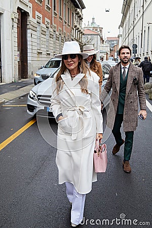 MILAN, ITALY - FEBRUARY 26, 2023: Woman with white coat and hat before Luisa Spagnoli fashion show, Milan Fashion Week street Editorial Stock Photo