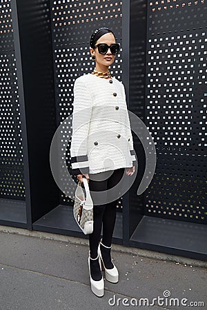 MILAN, ITALY - FEBRUARY 24, 2023: Woman with white jacket and shoes before Gucci fashion show, Milan Fashion Week street style Editorial Stock Photo