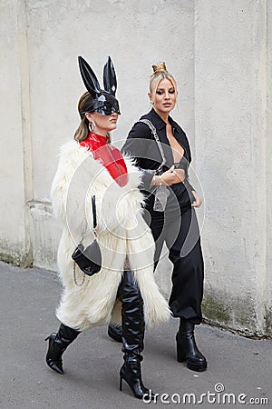 MILAN, ITALY - FEBRUARY 23, 2023: Women with white fur coat, black leather boots and rabbit mask before Prada fashion show, Milan Editorial Stock Photo