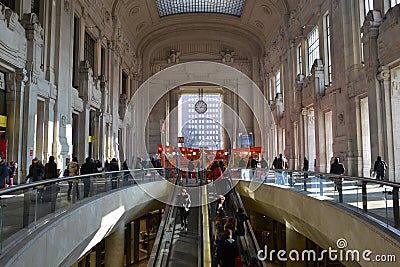 External escalator and decorated with red kiosks large corridor of the Milan Central railway station. Editorial Stock Photo