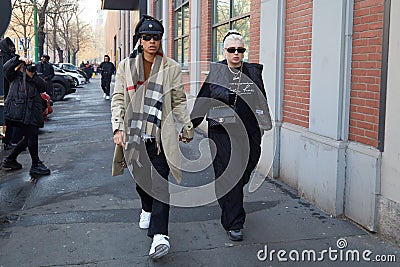 Man with beige coat and woman with black Chanel bag walking before Fendi fashion show, Milan Editorial Stock Photo