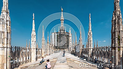 People visit the Milan Cathedral roof or Duomo di Milano. It is a top tourist attraction of Milan. Panoramic view of beautiful Editorial Stock Photo