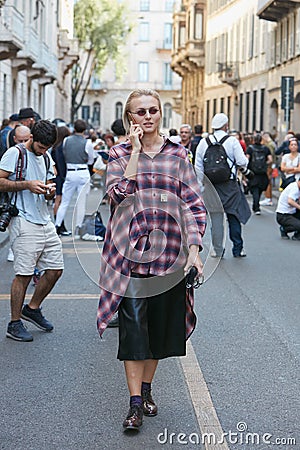 Woman with checkered shirt and black leather skirt before Giorgio Armani fashion show, Milan Editorial Stock Photo