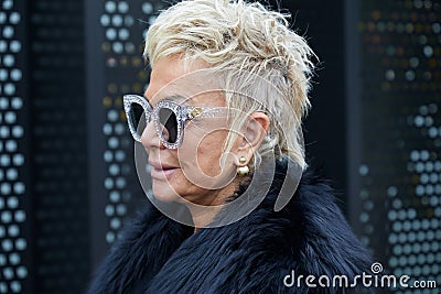 Woman with transparent and glitter Gucci sunglasses and black fur collar before Gucci fashion Editorial Stock Photo