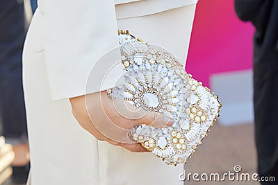 Woman with white dress and bag with gold and white gems decoration before Luisa Beccaria Editorial Stock Photo