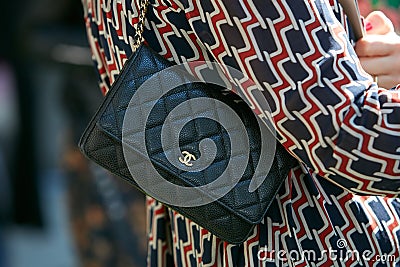 Woman with small Chanel black leather bag with golden logo before Giorgio Armani fashion show, Milan Fashion Editorial Stock Photo