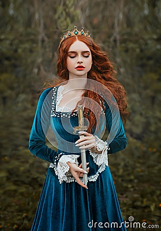 militant fantasy red-haired woman queen holding dagger in hands. Girl warlike princess warrior with sharp blade knife Stock Photo