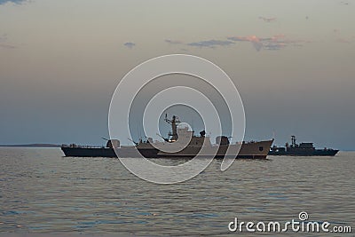 Military Battleships in a sea bay at sunset time Stock Photo