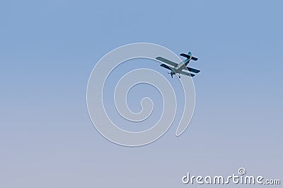 Military biplane flying in clear blue sky Editorial Stock Photo