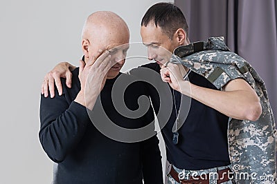 Military father hugs his son when they are reunited after a mission Stock Photo