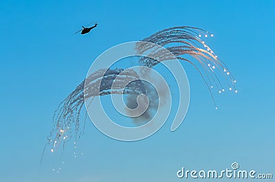 Military helicopter in action, launching rockets flares at an Ai Stock Photo